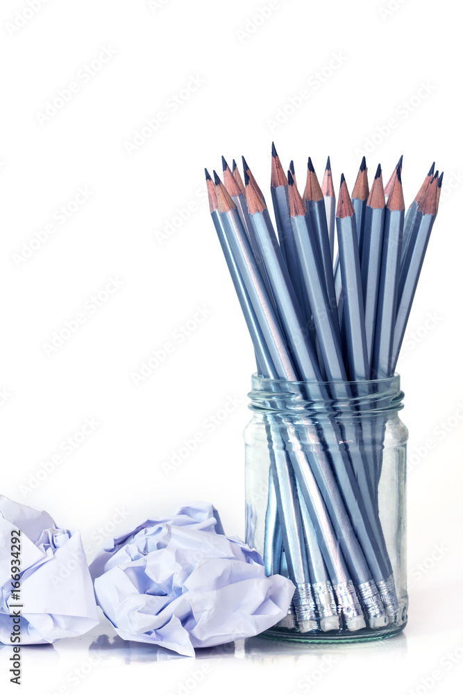 silver pencil in glass jar with the crumpled paper on white background with copy space , creative wo