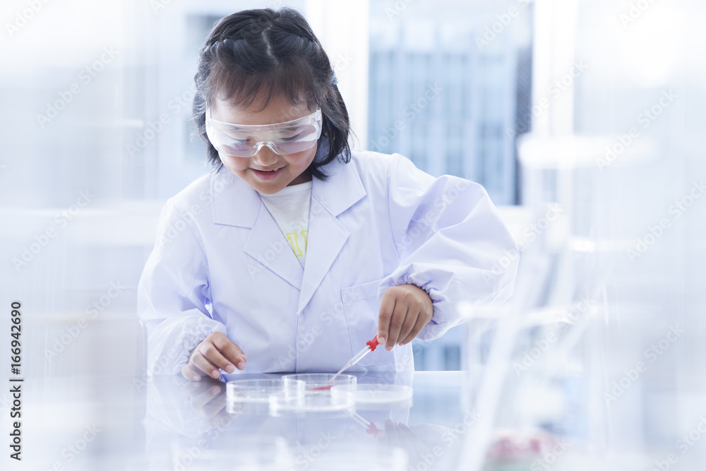 The girl is sucking liquid from a Petri dish with a dropper