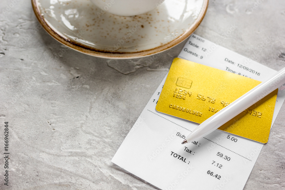 coffee and receipt bill for payment by credit card on stone table background