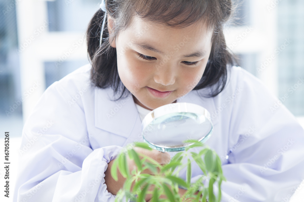 女孩正在用放大镜观察植物