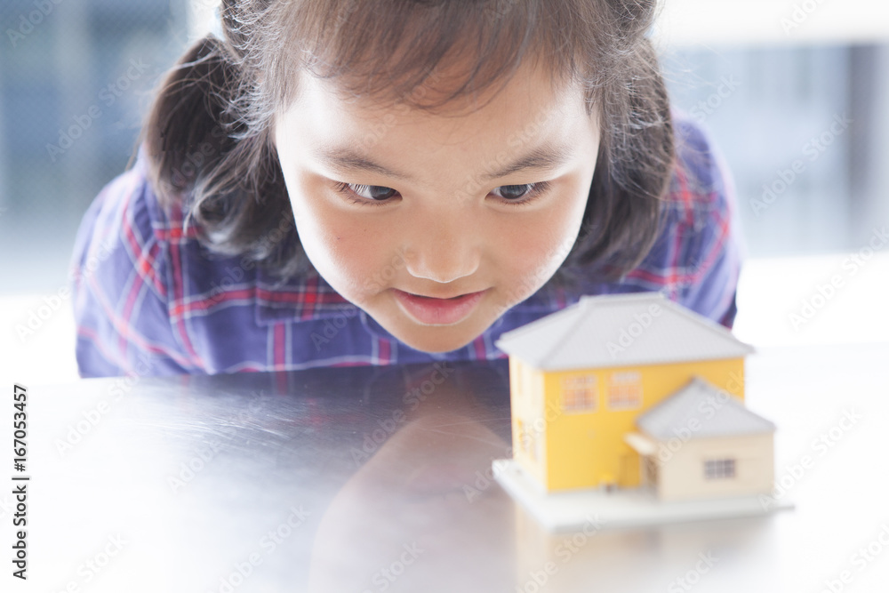 The girl is watching a miniature house