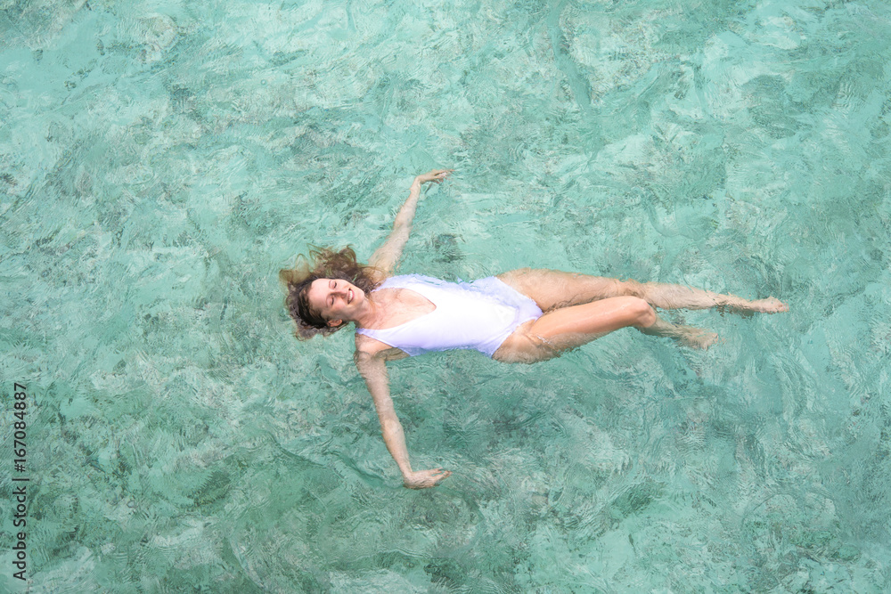 Young girl swimming in a turquoise water.