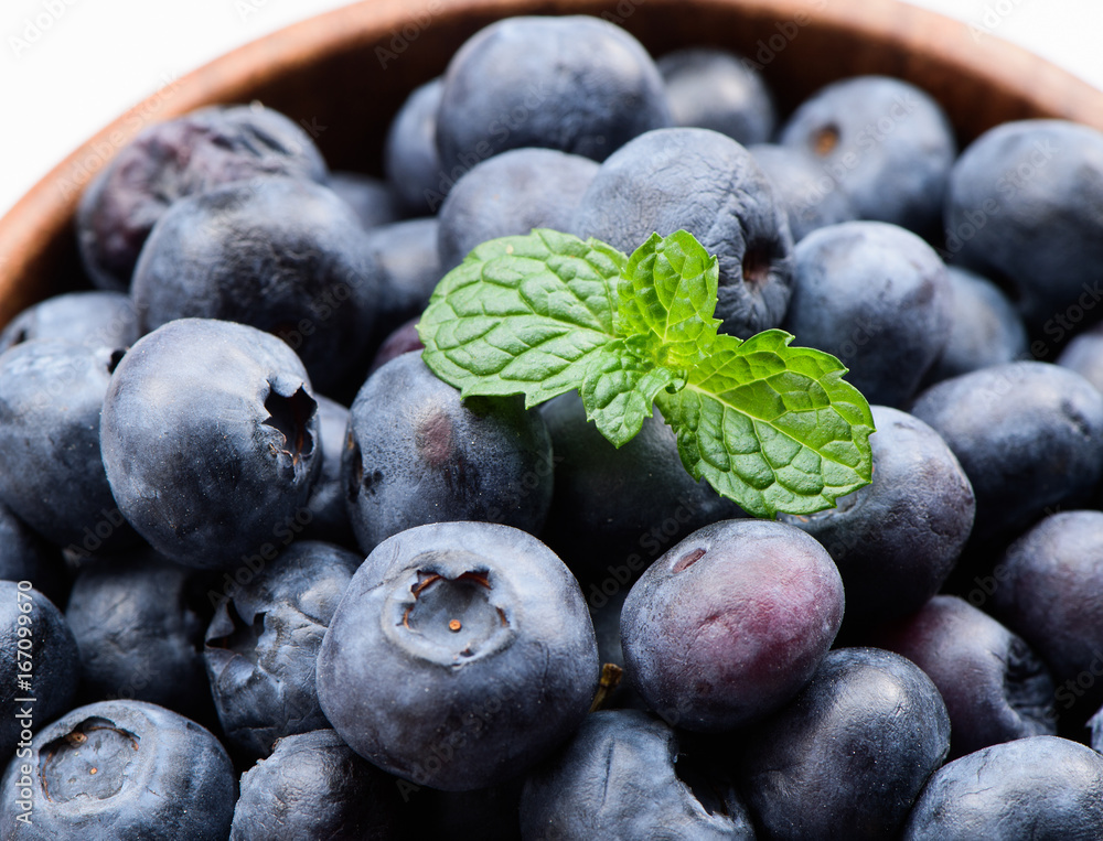 close up blueberry with vanilla mint in a wooden bowl isolated on white background
