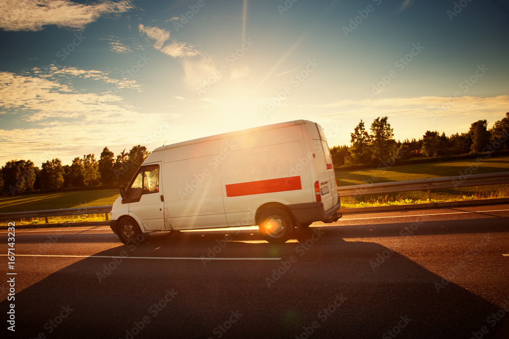 沥青路面上有一辆小卡车。货车在阳光明媚的日子里行驶