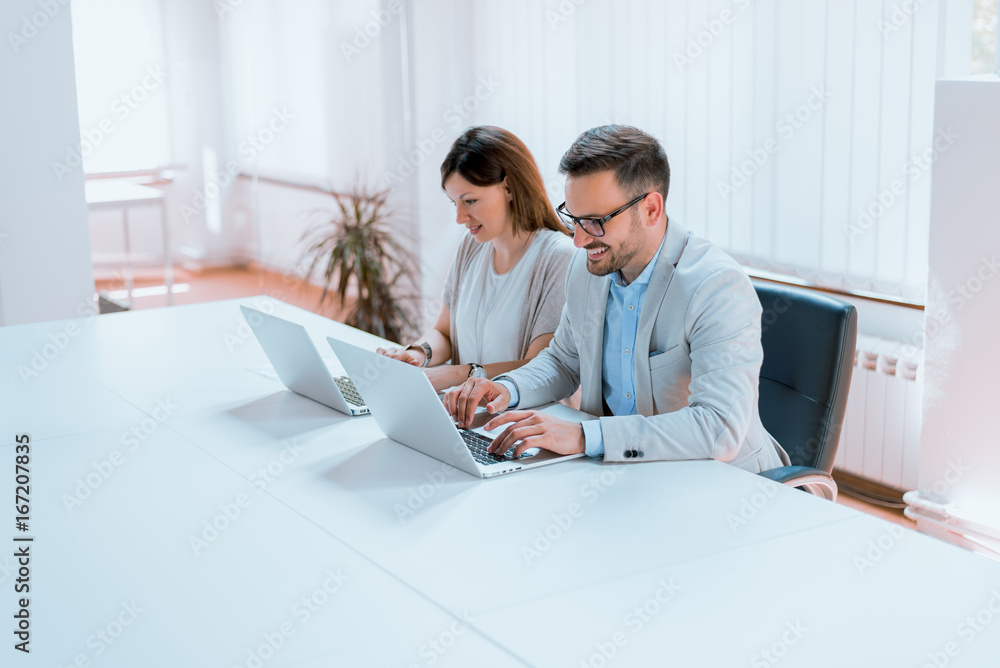 Modern business people working on laptop in office.