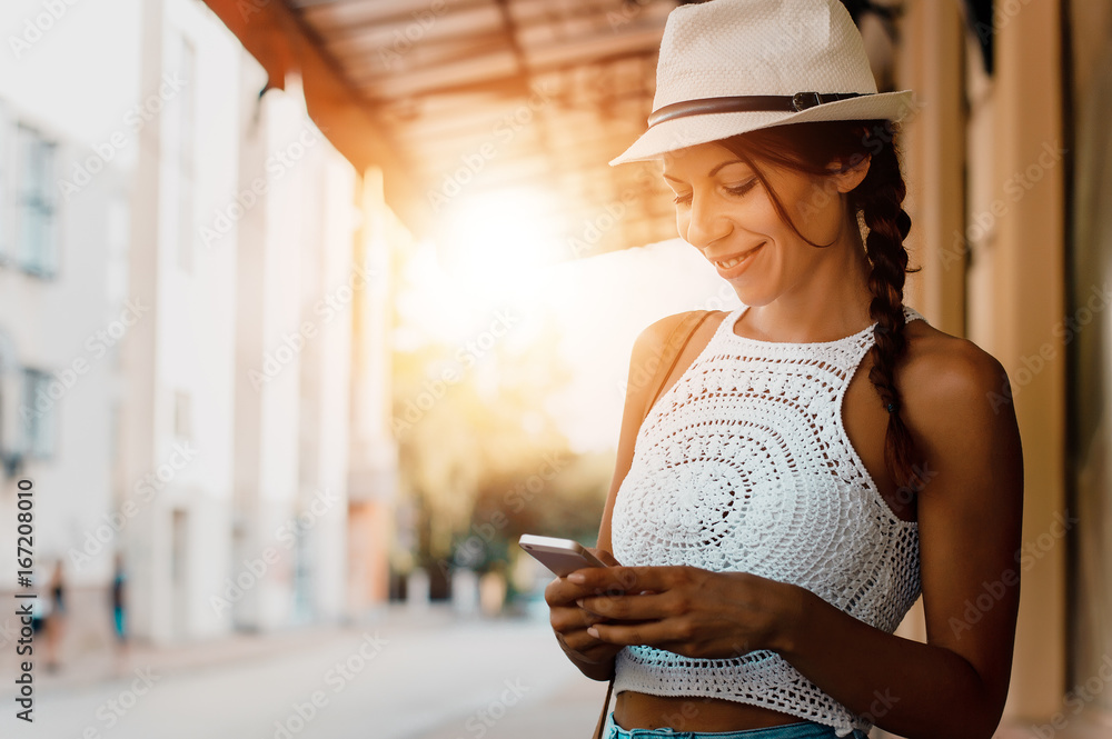 戴着夏季风格的布和帽子的女人在打电话。