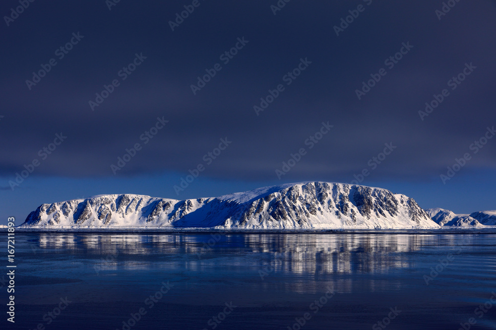 White snowy mountain, blue glacier Svalbard, Norway. Ice in ocean. Iceberg twilight, ocean. Pink clo