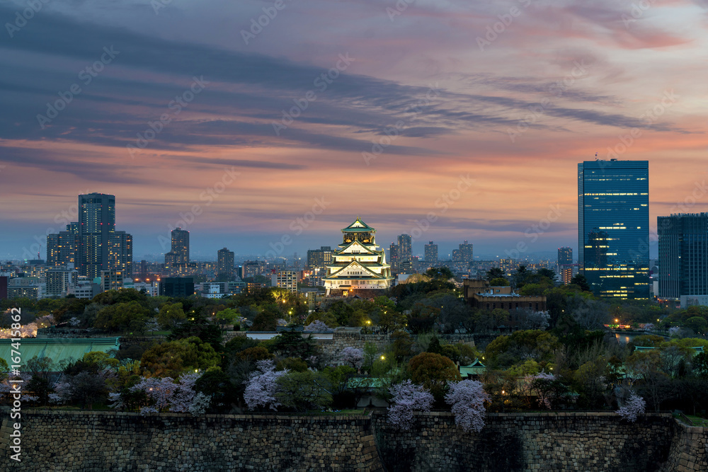 日本大阪，樱花盛开的大阪城堡和中心商业区。