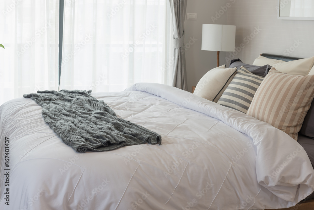 white blanket with set of pillows on bed