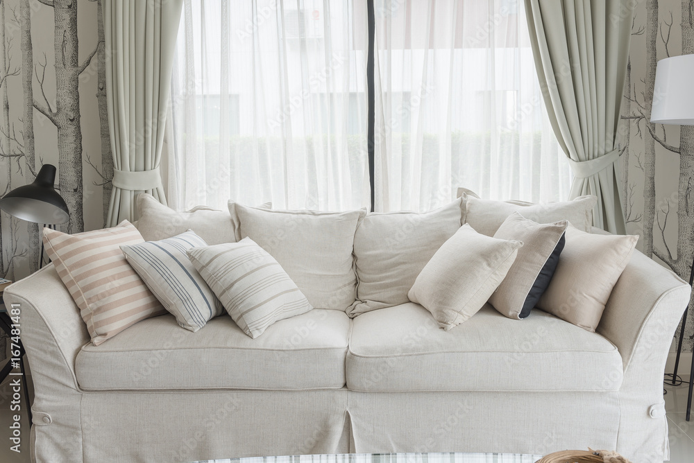 set of pillows on white classic sofa in living room