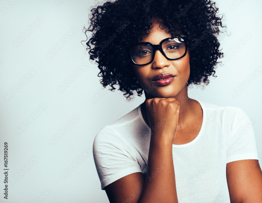 Confident African woman standing with a hand on her chin