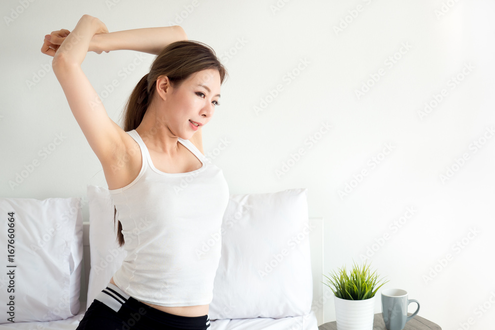 Young asian woman wake up happy, stretching and feeling fresh in the morning