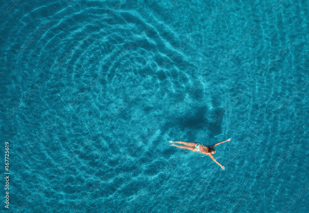 蓝色泻湖中游泳女子的鸟瞰图。土耳其奥卢代尼兹的地中海。夏季海景