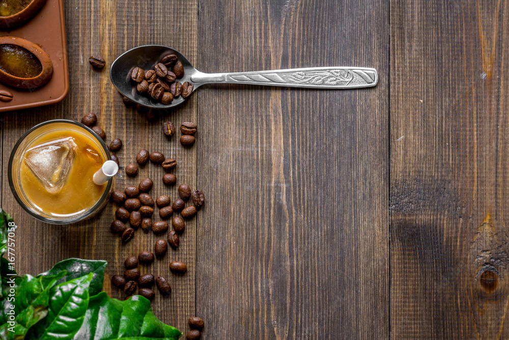 coffee with ice in glass on wooden background top view