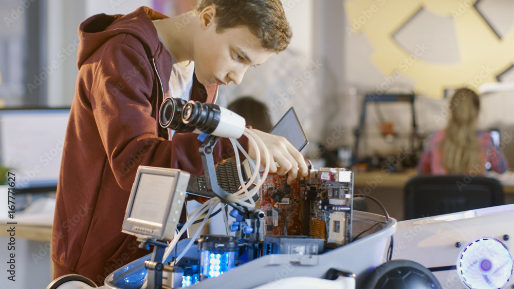 Boy Works on a Fully Functional Programable Robot with Bright LED Lights for His School Robotics Clu