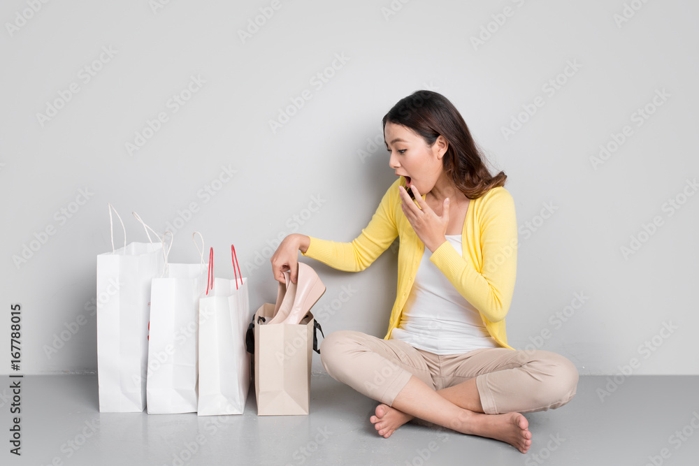 Happy asian woman shopping online at home sitting besides row of shopping bags