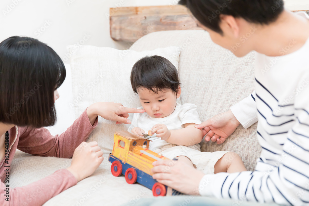 young asian family playing on sofa