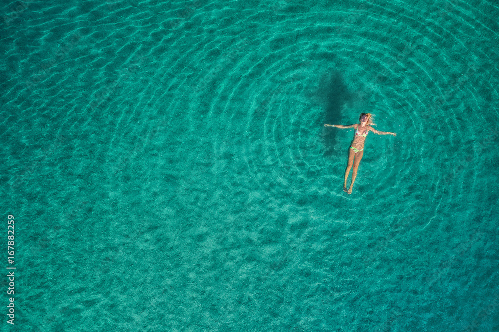 Aerial view of swimming woman in Blue Lagoon. Mediterranean sea in Oludeniz, Turkey. Summer seascape