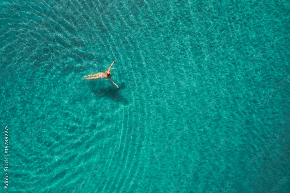 蓝色泻湖中游泳女子的鸟瞰图。土耳其奥卢代尼兹的地中海。夏季海景