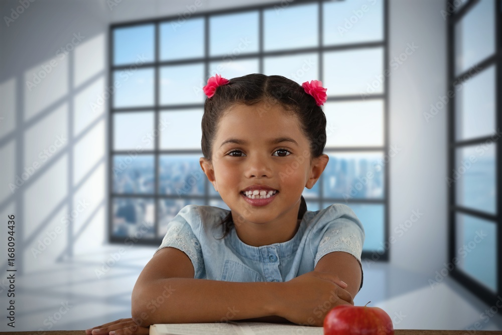 Composite image of smiling girl sitting at desk