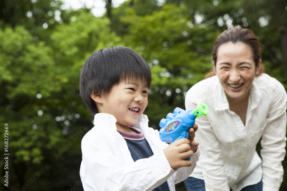 Mom and son playing bubbles in the park