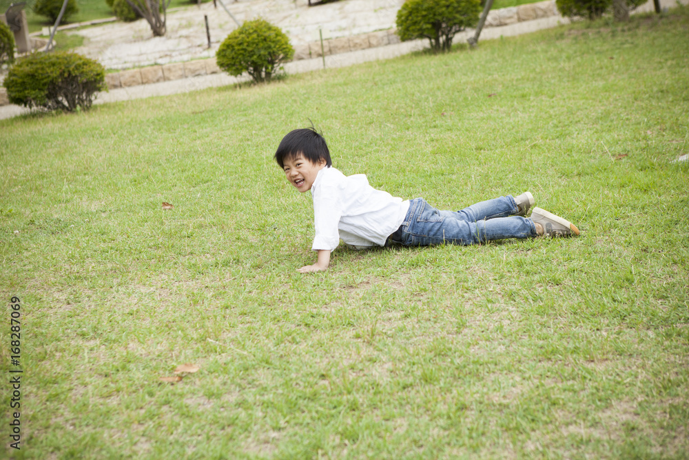 The boy is playing on the lawn