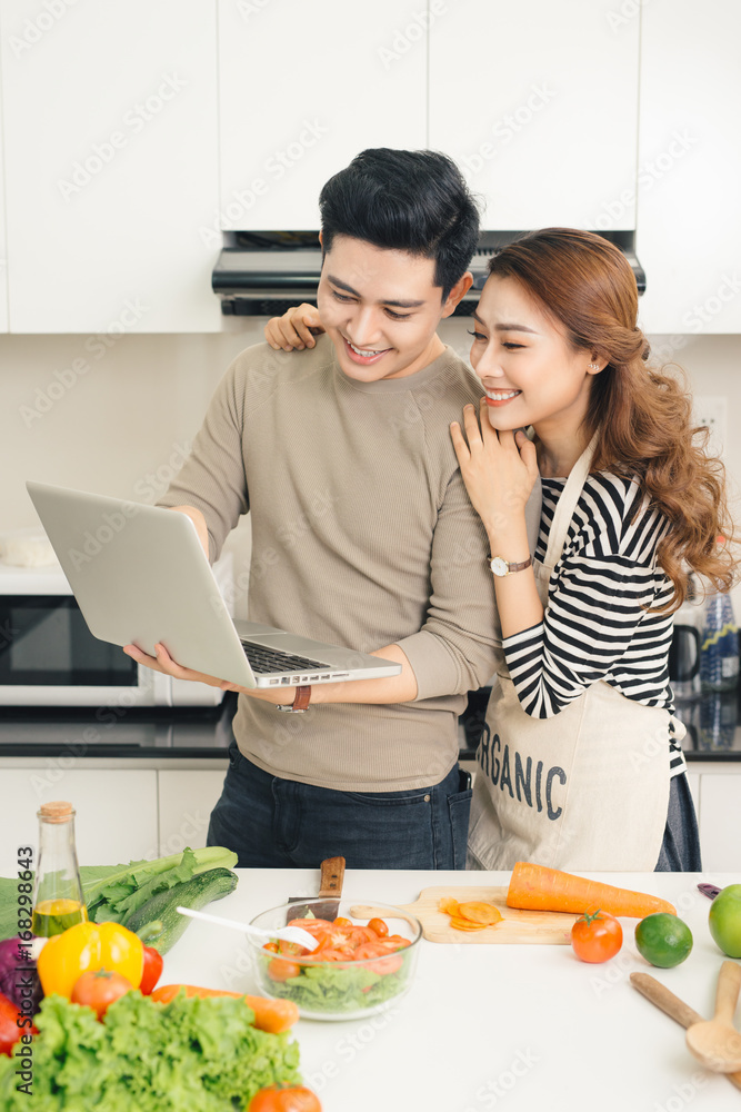 年轻夫妇用笔记本电脑查找食谱