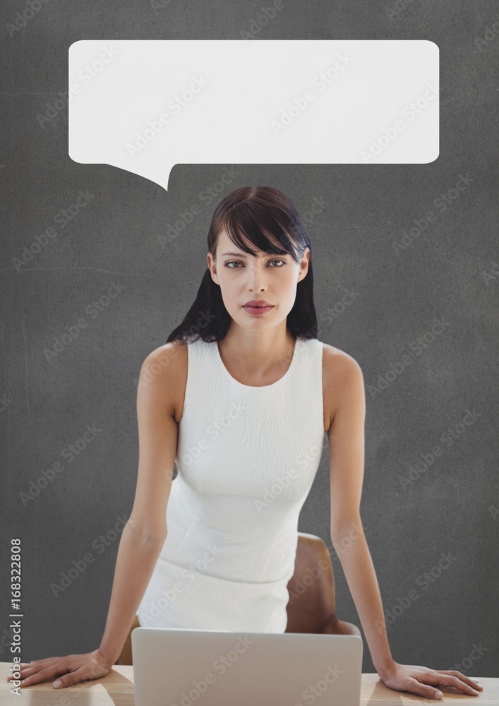 Business woman at table with speech bubble against grey backgrou