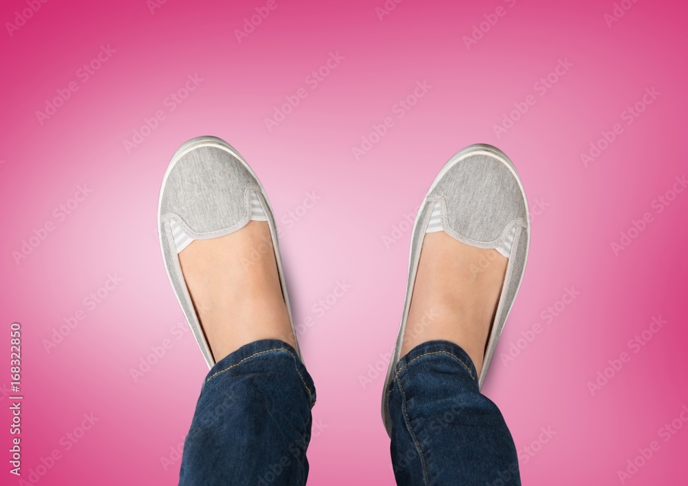 Grey shoes on feet with pink background