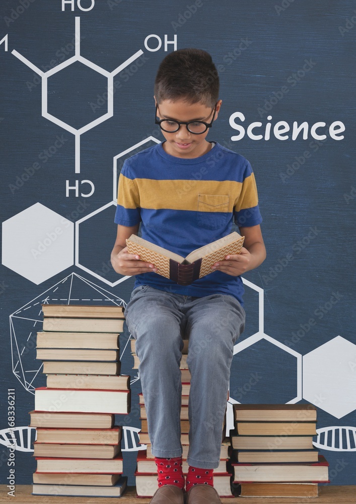 Student boy on a table reading against blue blackboard with scie