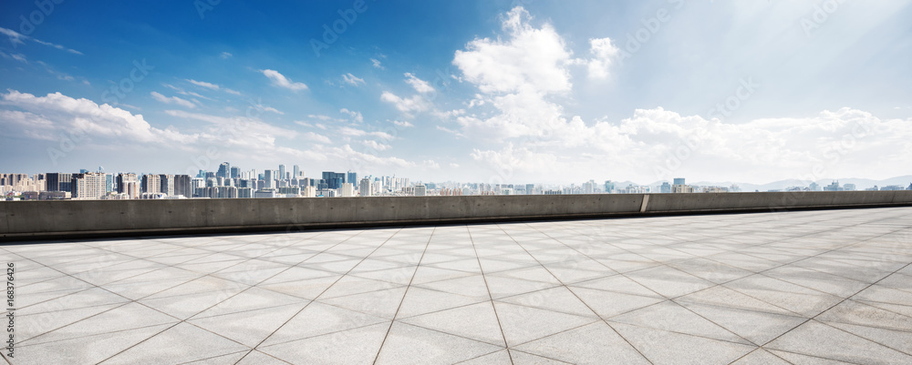 empty floor and cityscape of modern city against cloud sky