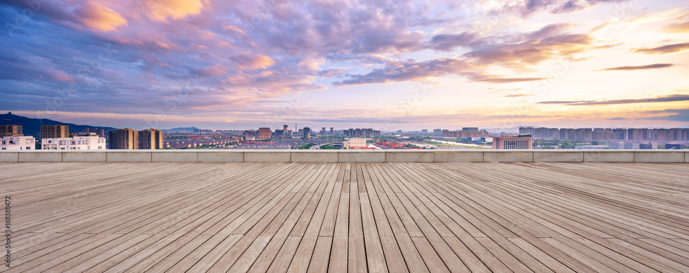 empty wood floor and cityscape of modern city against cloud sky