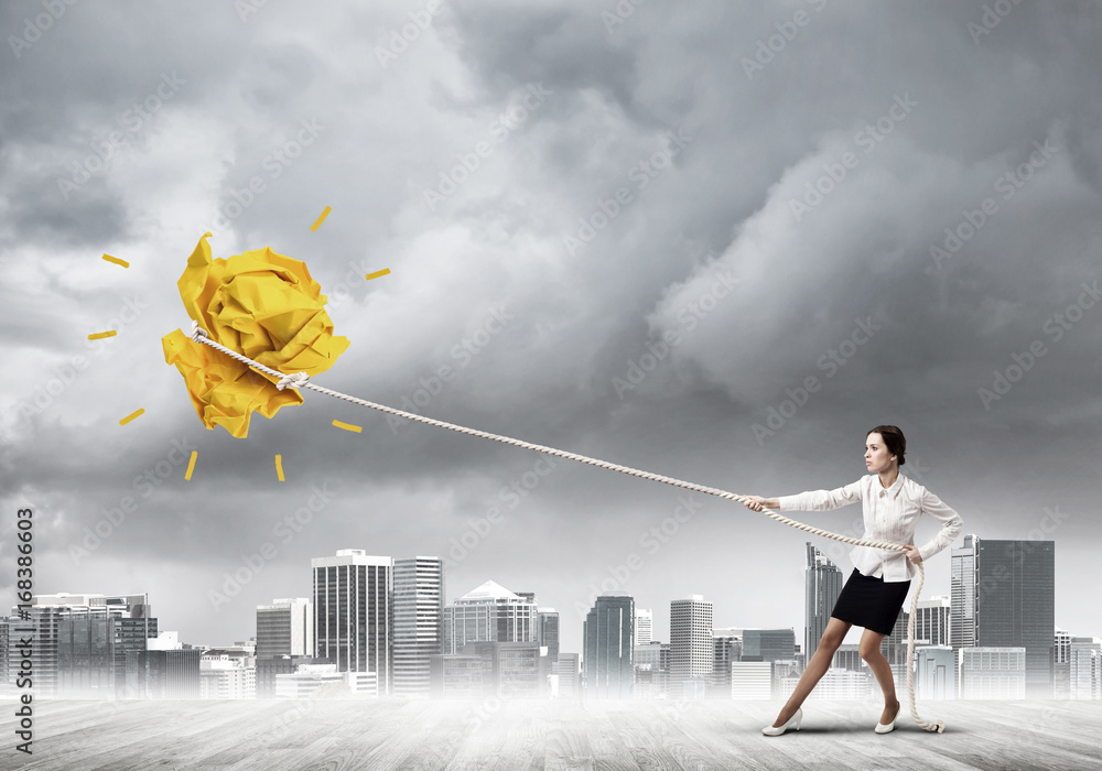 Businesswoman pulling paper ball with rope and making it raise up