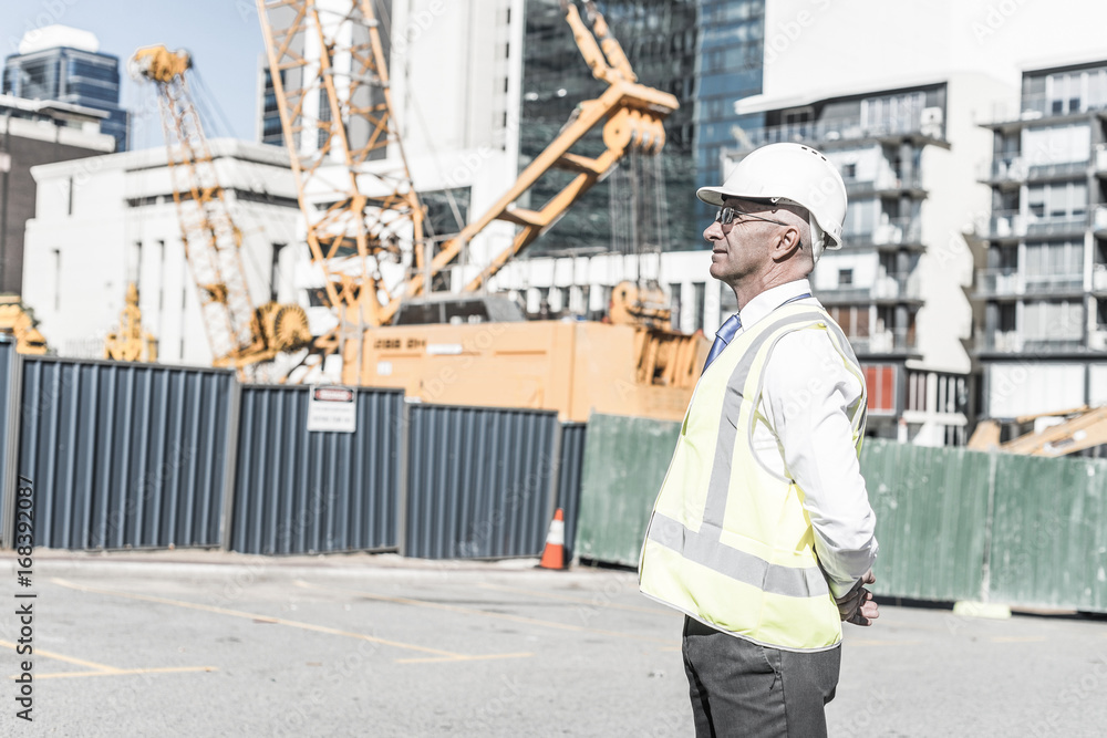 Senior foreman in glasses doing his job at building area on sunn