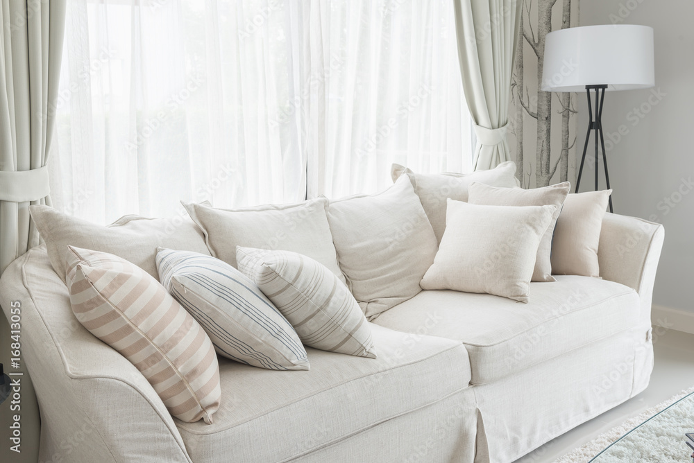 set of pillows on white classic sofa in living room