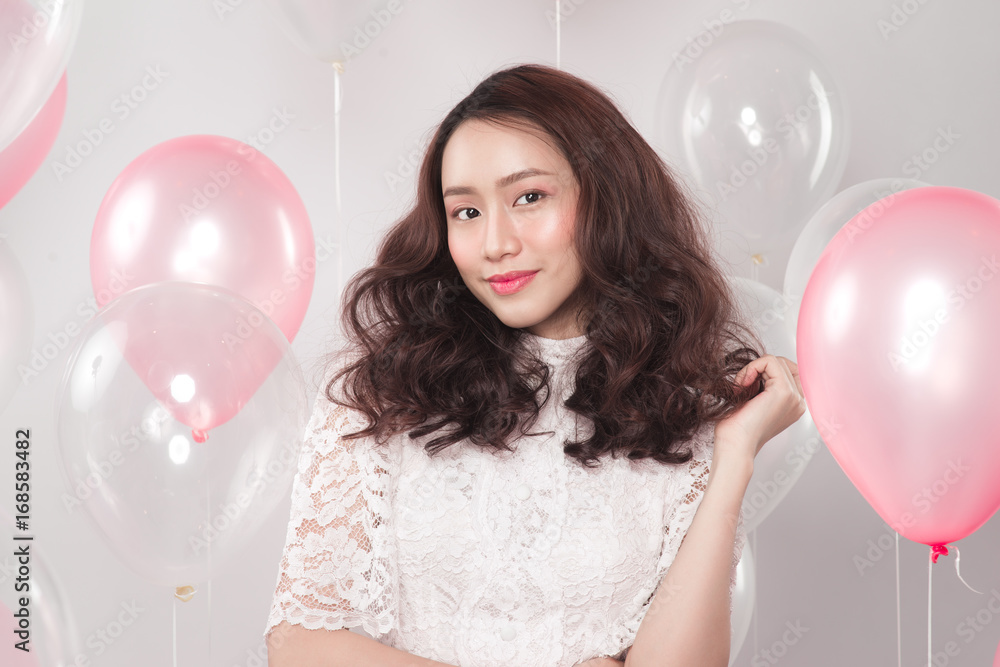 Asian pretty fashionable woman in white dress with pastel balloons