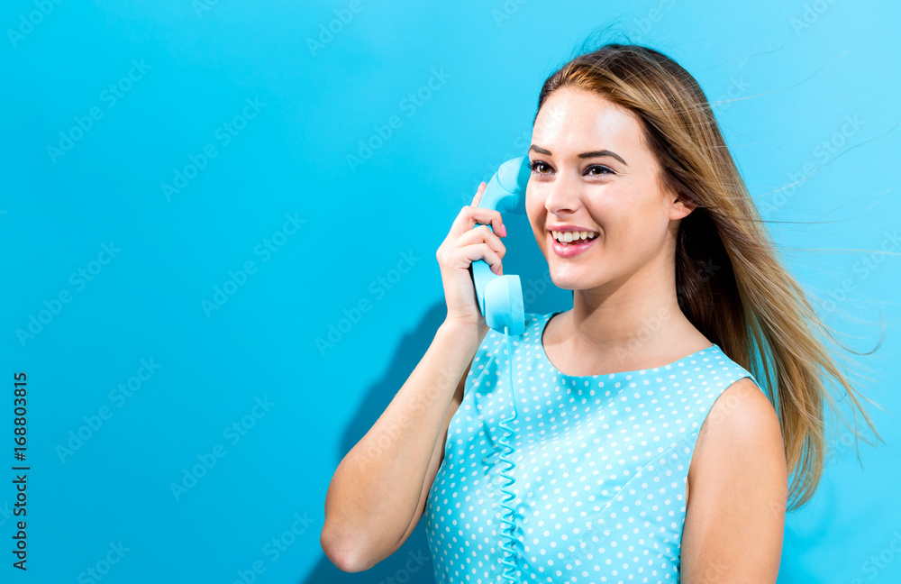 Young woman talking on old fashioned phone