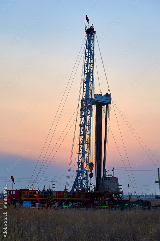 The oil derrick of oil field sunset