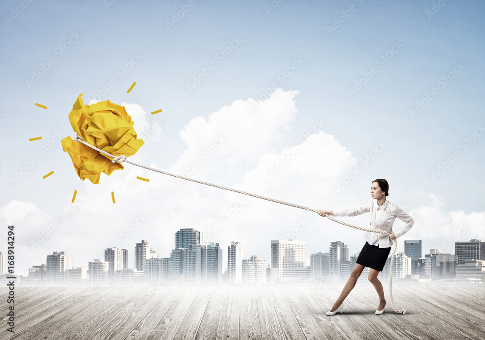 Businesswoman pulling paper ball with rope and making it raise up