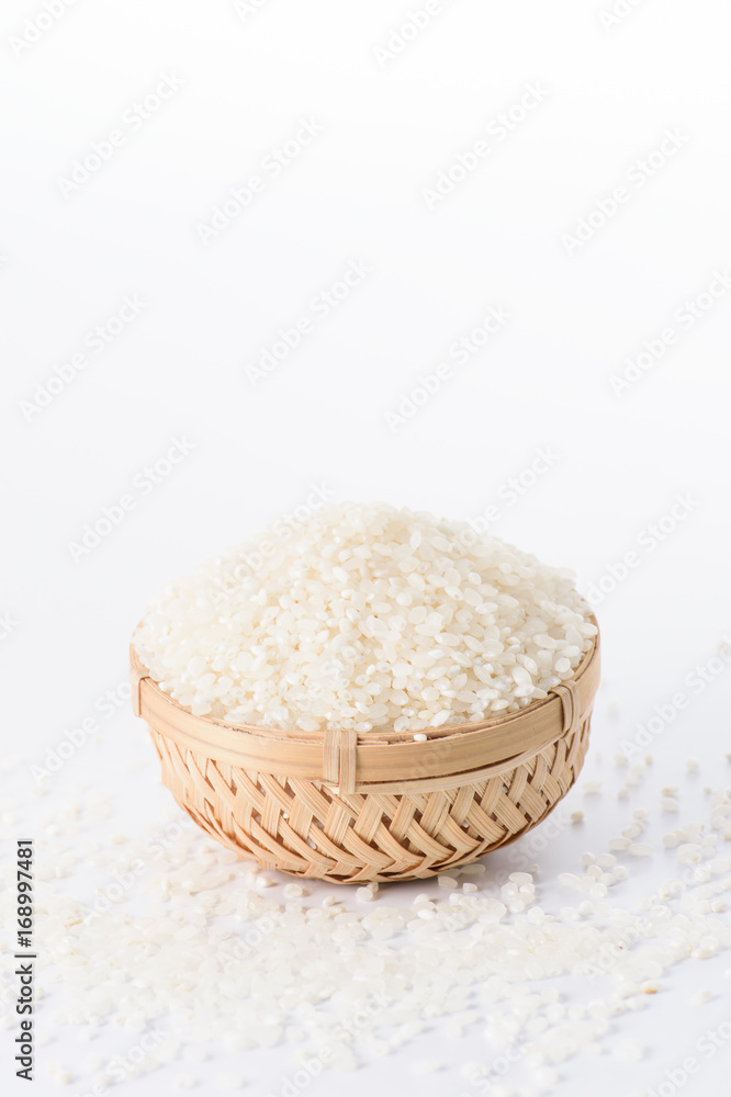 raw rice in a bamboo basket isolated on white background
