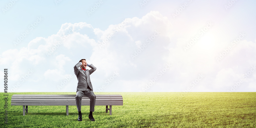 Young man in suit in park dont want to hear anything