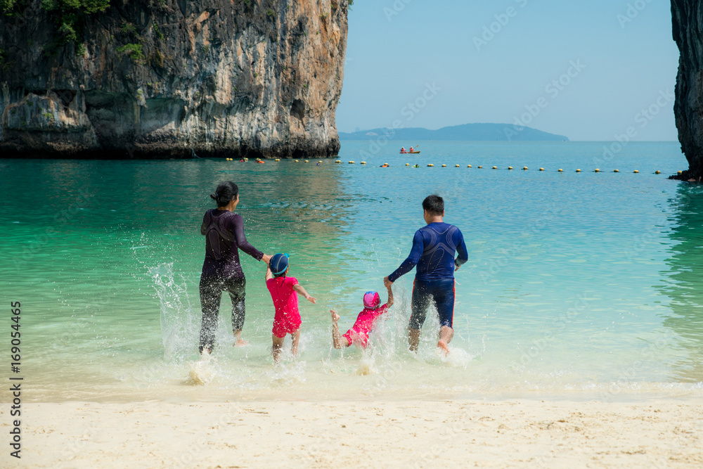 泰国普吉岛夏天，亚洲幸福家庭在海滩上奔跑的照片。夏天，旅行，弗吉尼亚州