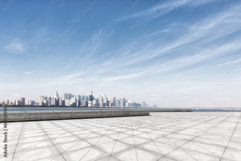 empty marble floor near water with cityscape of modern city