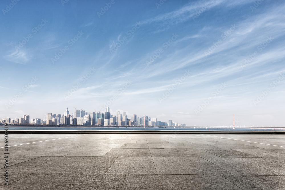 empty marble floor near water with cityscape of modern city