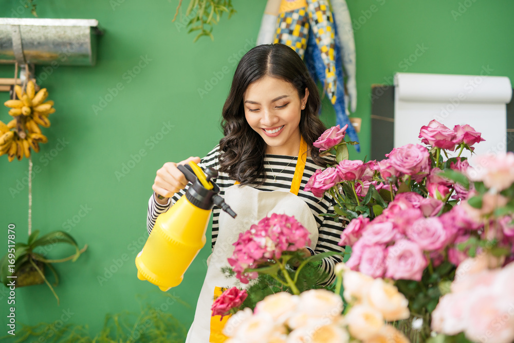 在花店工作的可爱专注的年轻亚洲女花艺师