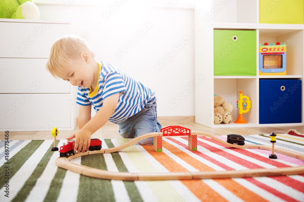 Little child playing with railroad