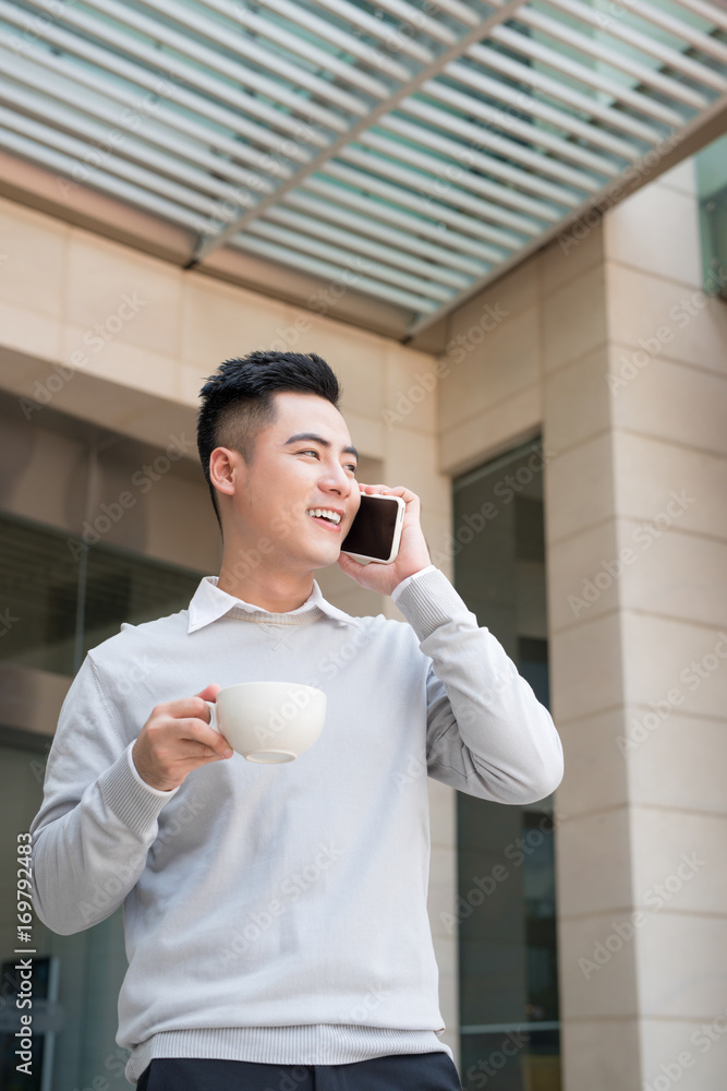 Happy asian business man on the phone, at the office