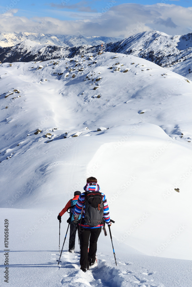 奥地利斯塔拜阿尔卑斯山，一男一女穿着雪鞋徒步旅行，蓝天下的山雪全景