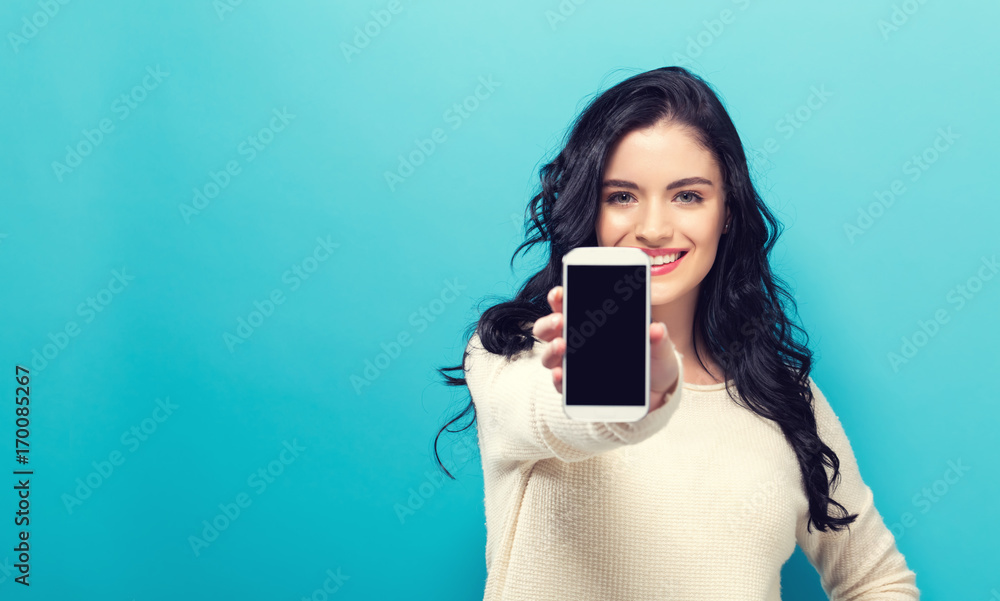 Young woman holding out a cellphone in her hand