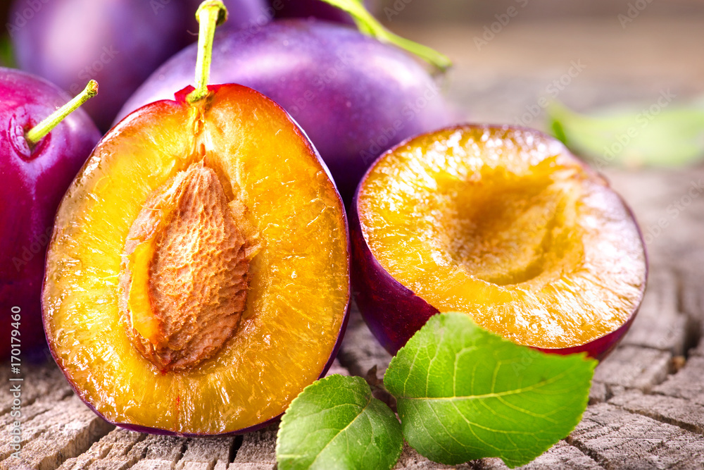 Plum. Juicy ripe organic plums closeup, over wooden background